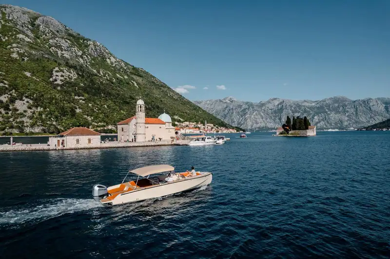 A private speedboat cruising past Our Lady of the Rocks
