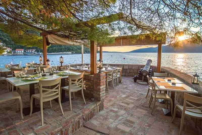 Restaurant tables at the water’s edge in a small harbour