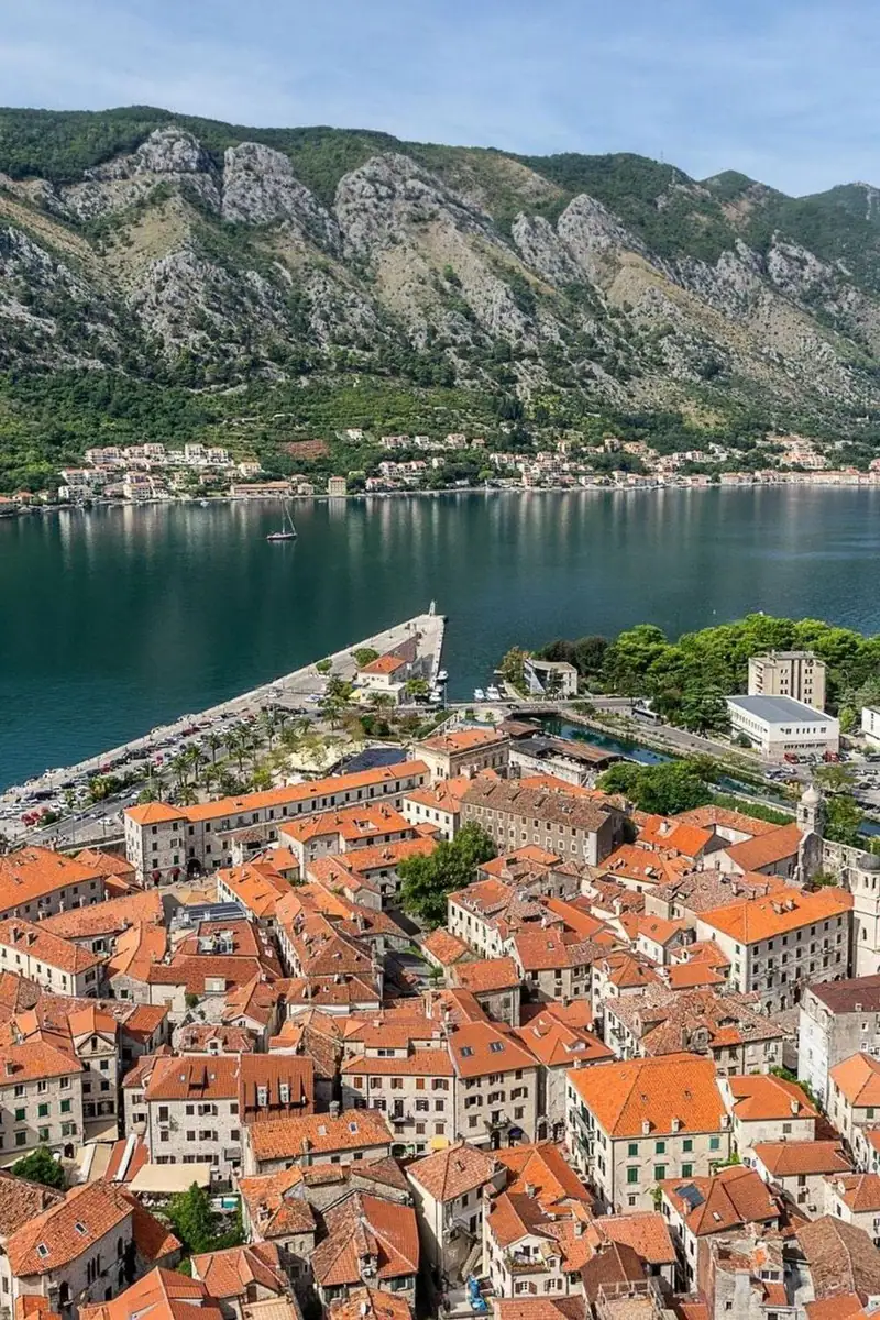 Kotor old town rooftops beneath the mountain and fortress walls