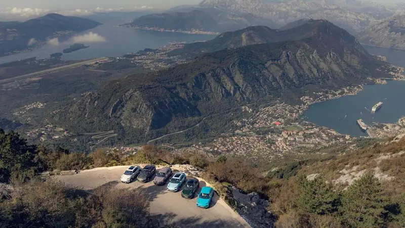 Cars parked at a viewpoint high above the Bay of Kotor