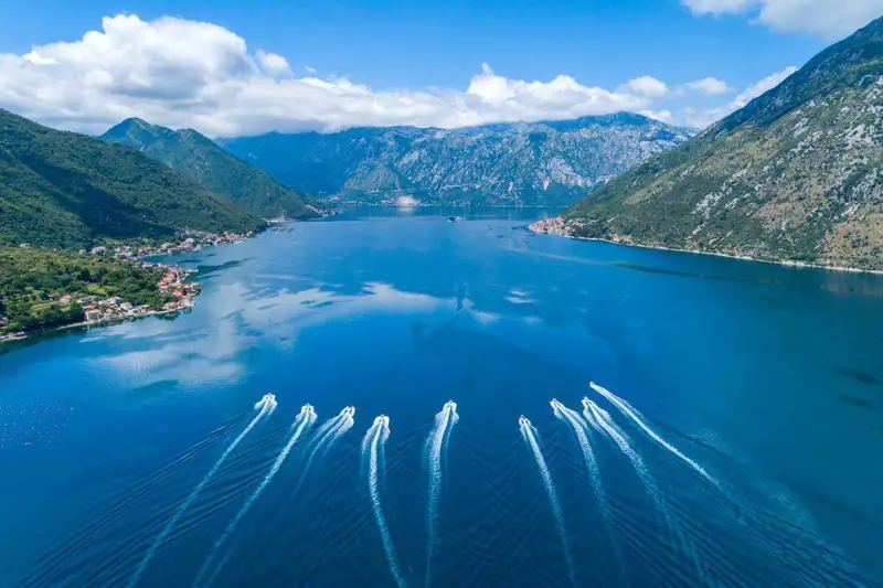 Speedboats leaving white wakes through the Verige strait