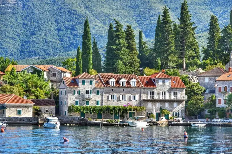 Stone houses and cypresses at the water’s edge on Luštica